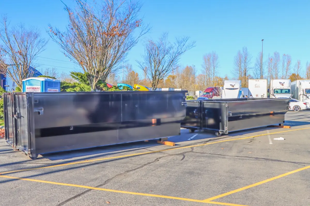 Professional dumpster rental service with roll-off container on residential driveway in Paris